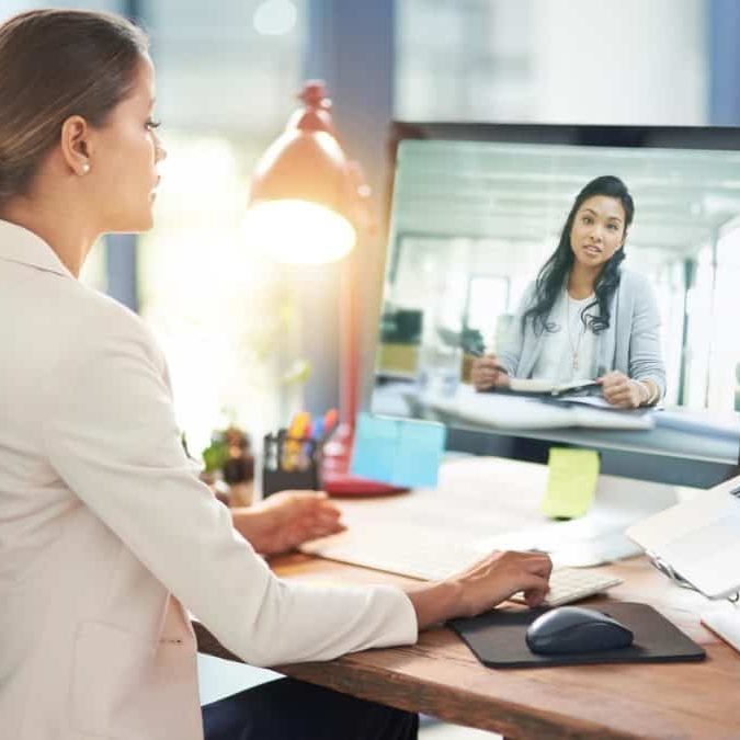 Virtual Assistant. Amber Assists. Person typing on laptop with sage colored plant beside them. glasses. apple watch. 